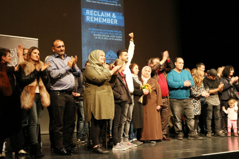 Familien Arslan und Yılmaz auf der Bühne mit anderen Betroffenen von rechter und rassistischer Gewalt, die sich mit ihnen solidarisieren. „Möllner Rede im Exil“ in Berlin, 2017. © Bengü Kocatürk-Schuster